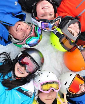 ski instructor and children laying on ground